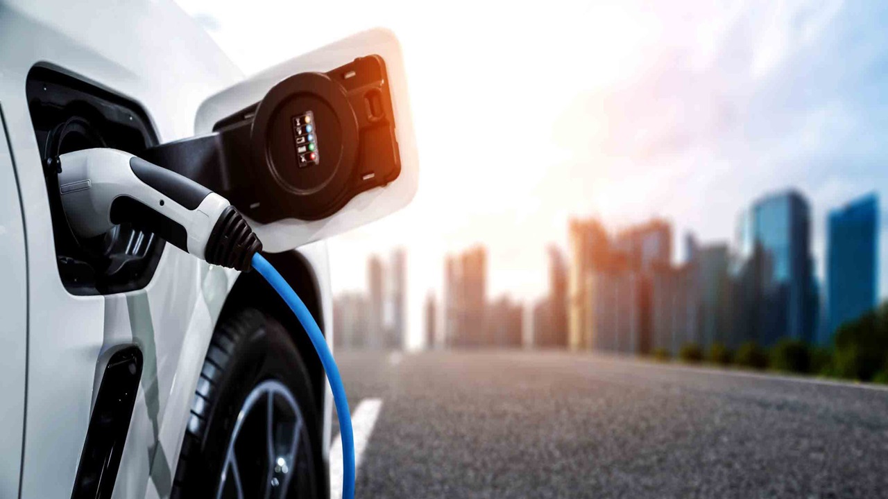EV Charging EV Charging On White Car With City Buildings Background Scaled 1